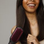 일상 속 헤어 건강, ‘자연스러운 관리’가 트렌드로 a woman holding a hair brush in her hand