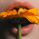 “입 냄새가 너무 신경 쓰여요”… 잘못된 위장 기능이 원인일 수 있습니다 a hand holding a yellow flower