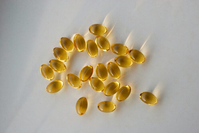 Photo by Olga Kovalski a pile of fish oil capsules sitting on top of a table