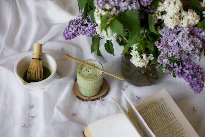 Photo by Jovan Vasiljević a vase of flowers and a whisk on a table