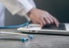 “AI, 우리 집 건강 지킴이로”…일상에 녹아든 스마트 건강 관리법 Doctor typing on a laptop with a stethoscope nearby.