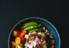건강한 식습관, ‘한 그릇 밥상’에서 시작하는 소소한 변화 a blue bowl filled with vegetables and a wooden spoon