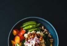 건강한 식습관, ‘한 그릇 밥상’에서 시작하는 소소한 변화 a blue bowl filled with vegetables and a wooden spoon